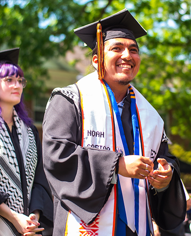 A Kalamazoo college graduate walks across the stage to receive their diploma.